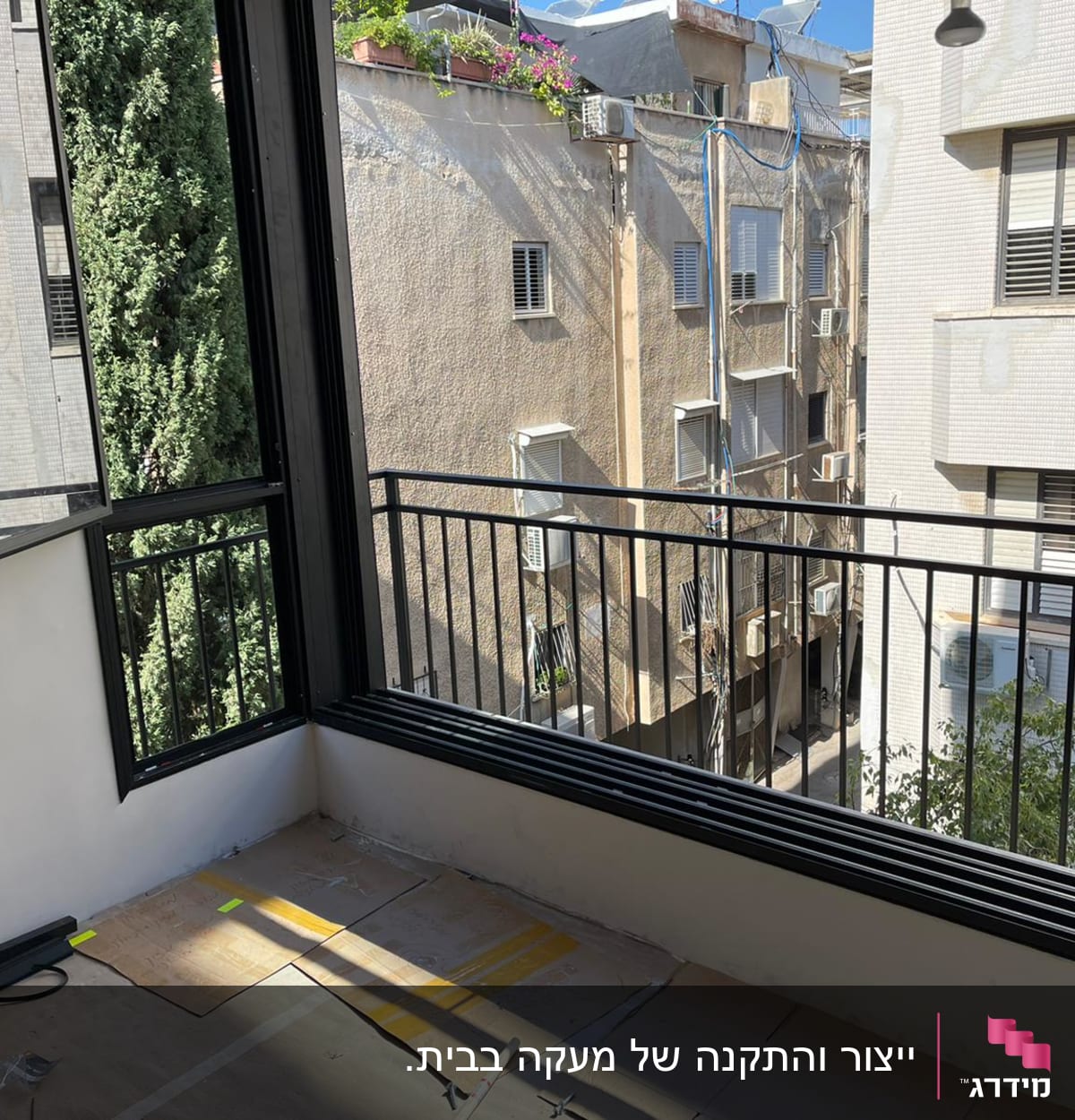 חלון פתוח עם מסגרת שחורה ומעקה ברזל